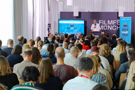 Besucher*innen des Filmfestes München, die bei einer Präsentation anwesend sind