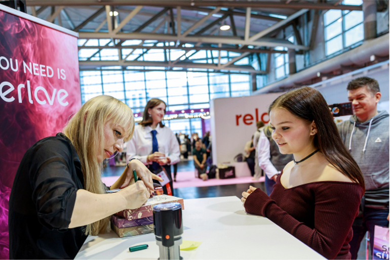 Besucherin bekommt Autogramm in Buch