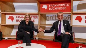 Nancy Faeser und Michel Friedman reichen sich auf einer Bühne die Hand. 