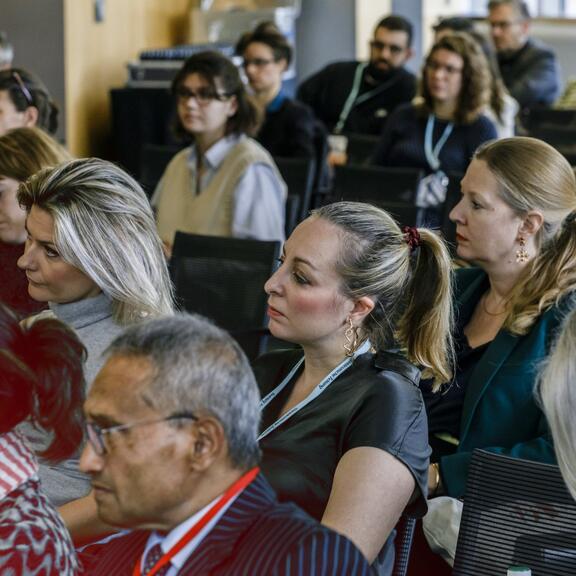 Menschen im Publikum hören gespannt zu 