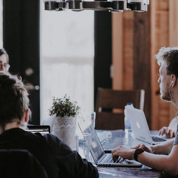 Eine Gruppe von Menschen arbeitet konzentriert an ihren Laptops